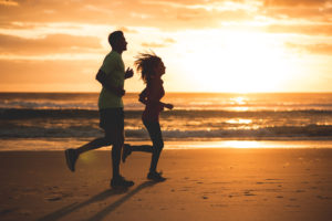 silhouette d'un couple en train de courir à la plage